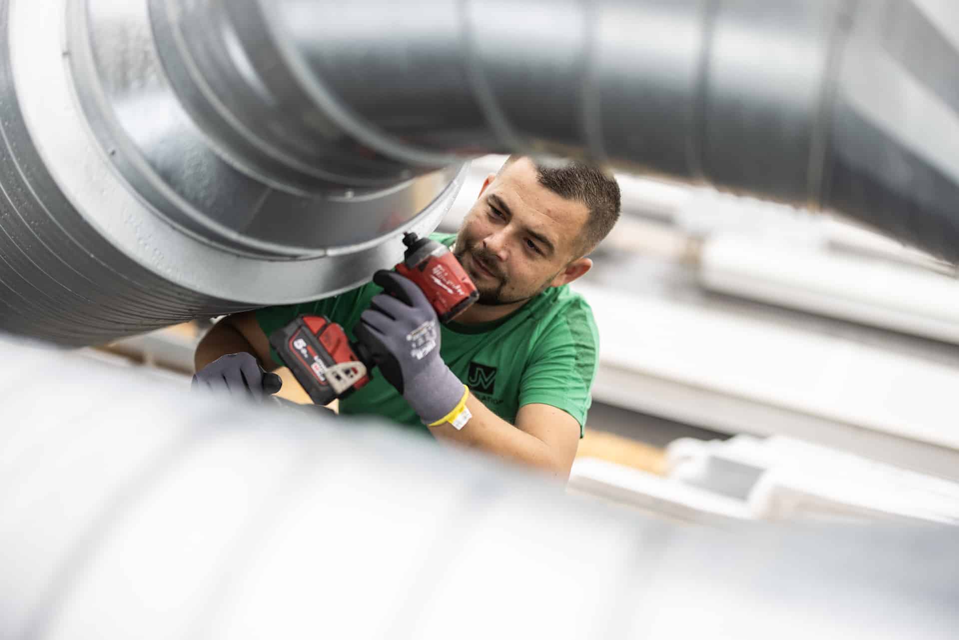 Der skrues skruer i et ventilationsanlæg